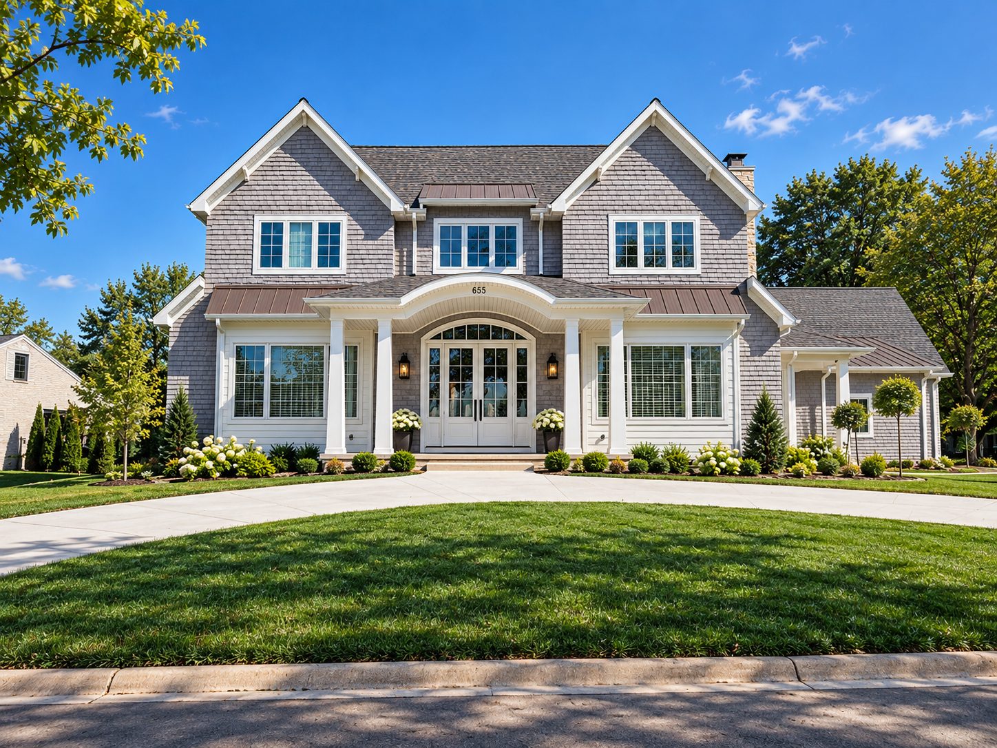 A shingle-style custom home with a covered front porch